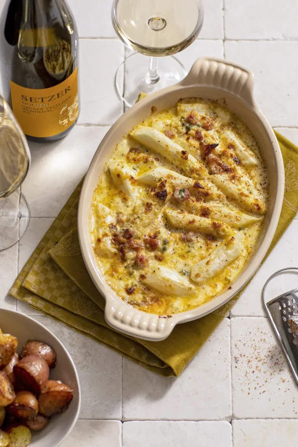 gegratineerde witte asperges met ham en kaas geserveerd met krieltjes